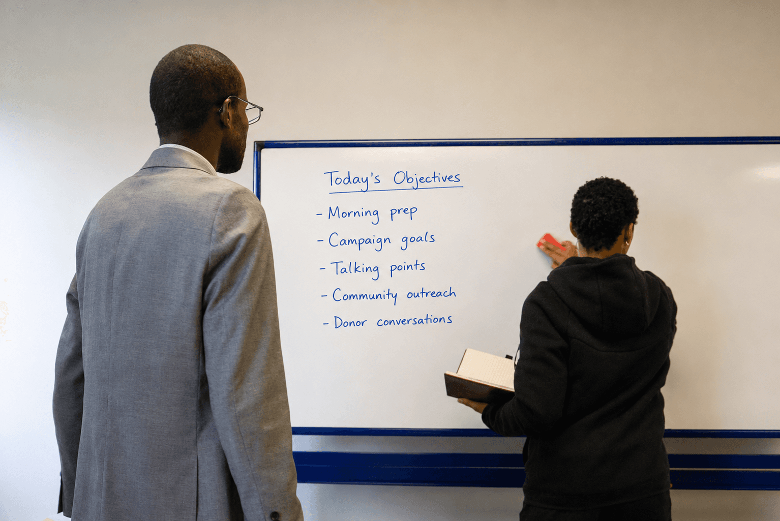 Glo team members reviewing the day's campaign objectives on a whiteboard